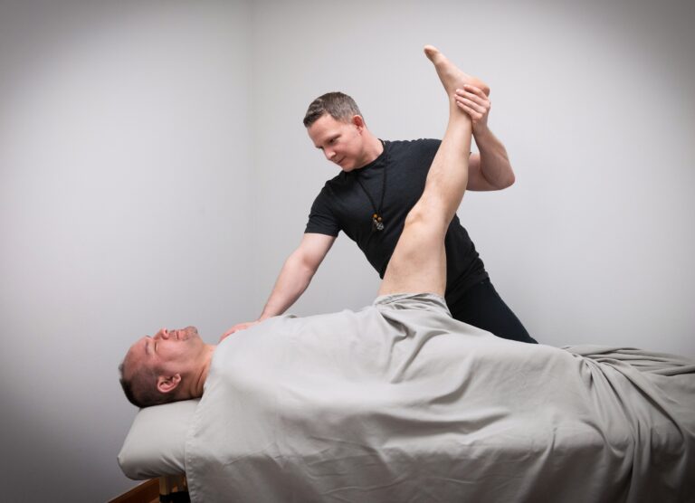 Michael Elder LMT and Reiki Master guiding client through a restorative hamstring stretch
